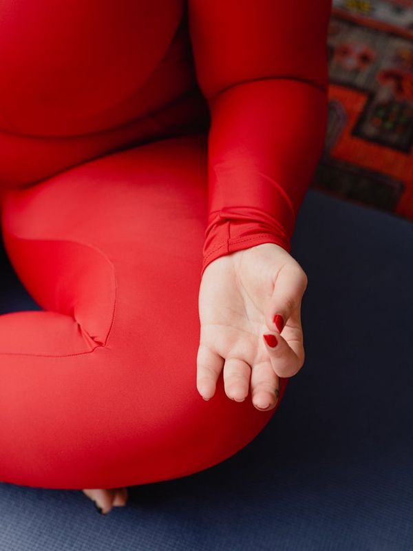 A calm and focused woman preparing her yoga mat in a peaceful room.